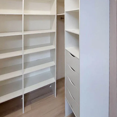 Светлая гардеробная комната с полками и штангами